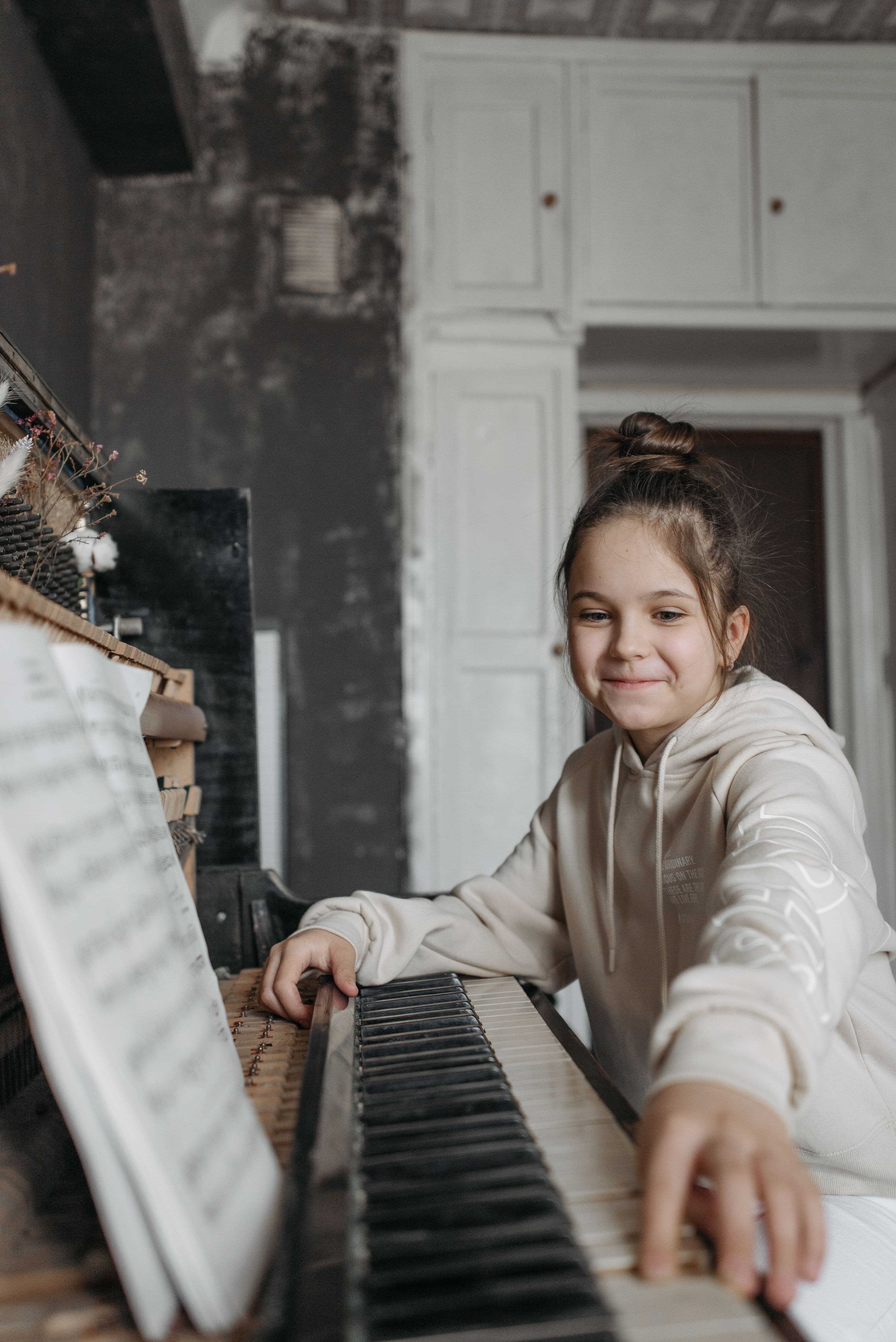 Young piano student sitting at a piano during a lesson